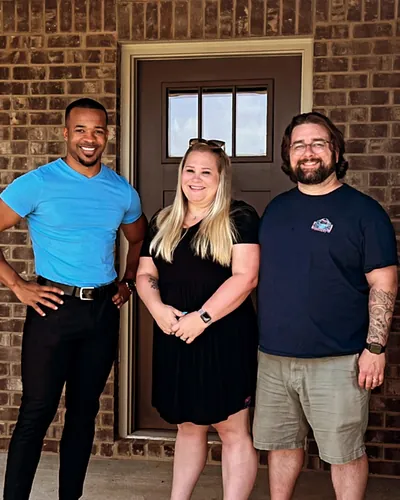 Teré Calloway with a couple at the front door of their new home