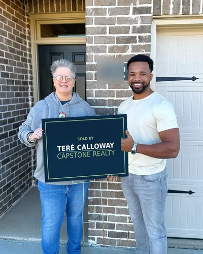 Teré with a buyer holding a Sold by Teré Calloway sign on closing day