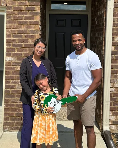 Teré with a mother and daughter holding the keys to their new home