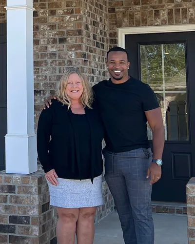 Teré with a buyer on the front porch of her new home