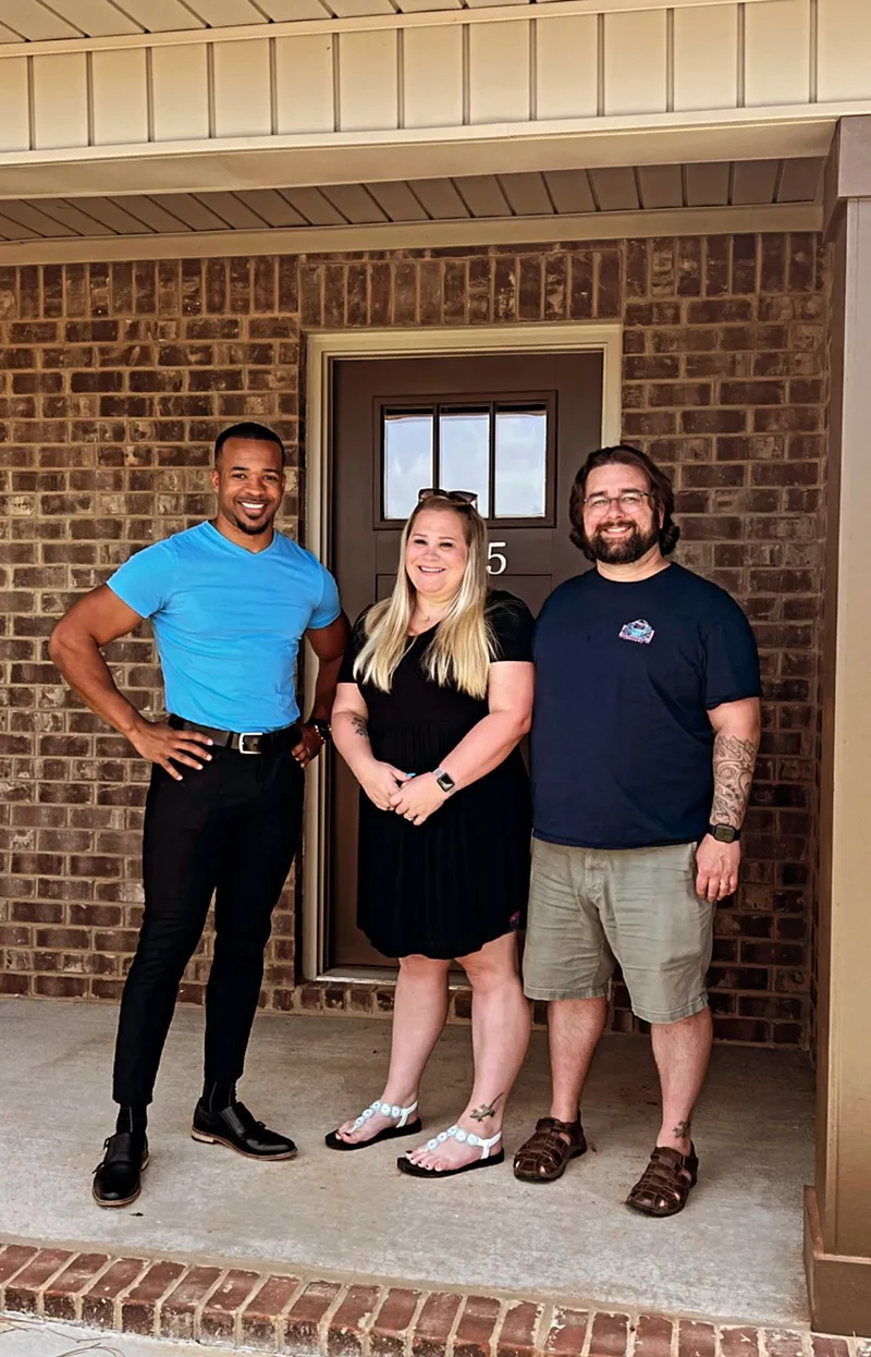 Teré Calloway with buyers at the front door of their new home